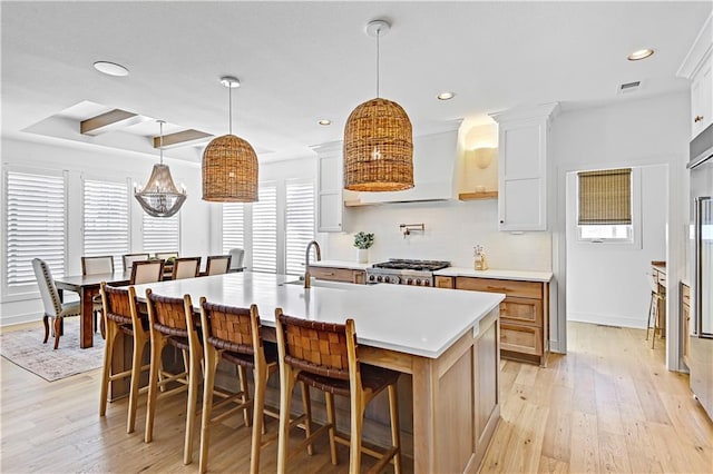 17029 King St, Overland Park, KS 66221 - kitchen with a sink, light countertops, light wood finished floors, range, and a breakfast bar area
