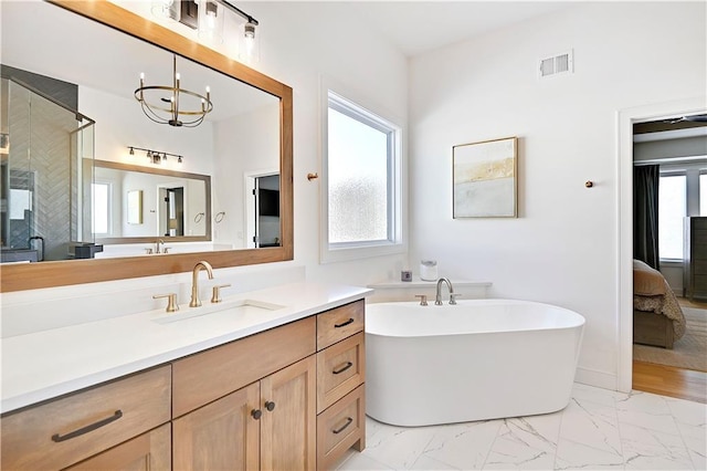 17029 King St, Overland Park, KS 66221 - ensuite bathroom featuring a soaking tub, marble finish flooring, vanity, a chandelier, and a shower stall
