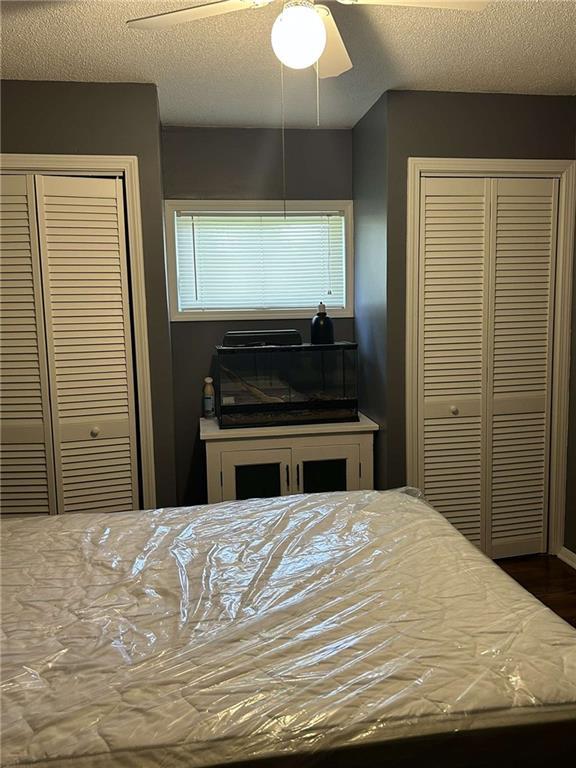241 E S St, Peculiar, MO 64078 - bedroom featuring a textured ceiling, a ceiling fan, a closet, and wood finished floors