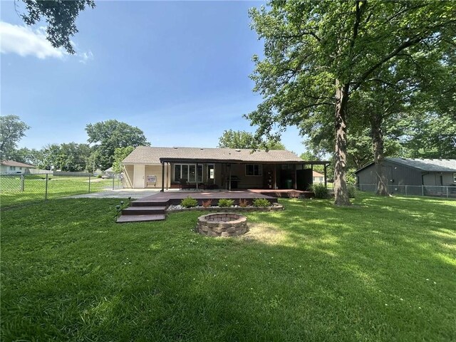 241 E S St, Peculiar, MO 64078 - rear view of house with an outdoor fire pit, a fenced backyard, and a wooden deck