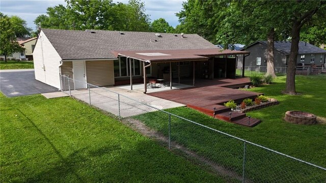 241 E S St, Peculiar, MO 64078 - back of property featuring an outdoor fire pit, a patio area, a fenced backyard, and a shingled roof