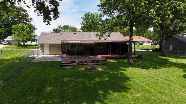 241 E S St, Peculiar, MO 64078 - back of house with a fire pit, a fenced backyard, a deck, and a patio area