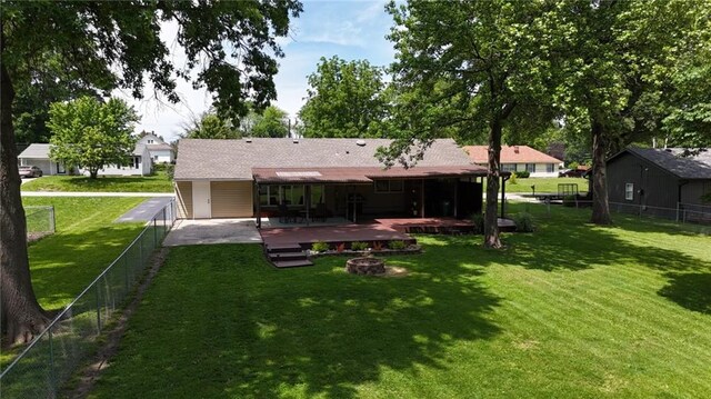241 E S St, Peculiar, MO 64078 - back of property featuring a deck, a fenced backyard, and an outdoor fire pit