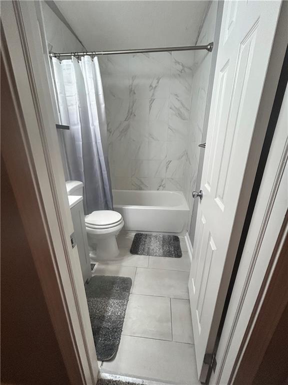409 N Geronimo Dr, Independence, MO 64056 - bathroom with shower / tub combo with curtain, vanity, and tile patterned floors