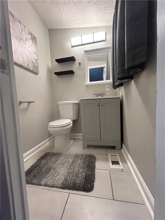 409 N Geronimo Dr, Independence, MO 64056 - half bath with a textured ceiling, vanity, and tile patterned flooring