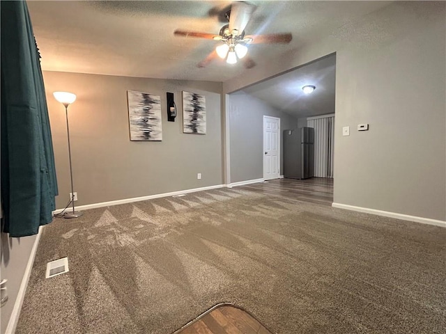 409 N Geronimo Dr, Independence, MO 64056 - empty room with ceiling fan, carpet flooring, vaulted ceiling, and a textured ceiling