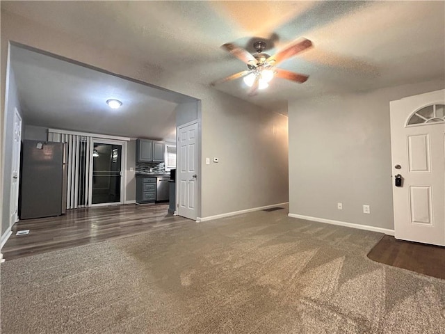 409 N Geronimo Dr, Independence, MO 64056 - unfurnished living room with dark carpet, ceiling fan, and a textured ceiling