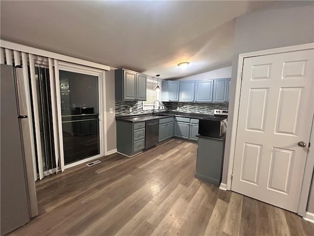 409 N Geronimo Dr, Independence, MO 64056 - kitchen featuring dishwasher, gray cabinets, dark countertops, decorative backsplash, and dark wood-type flooring