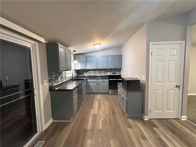 409 N Geronimo Dr, Independence, MO 64056 - kitchen with dark countertops, stainless steel appliances, gray cabinetry, tasteful backsplash, and lofted ceiling