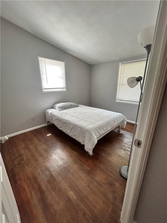 409 N Geronimo Dr, Independence, MO 64056 - bedroom with lofted ceiling and dark wood-style floors