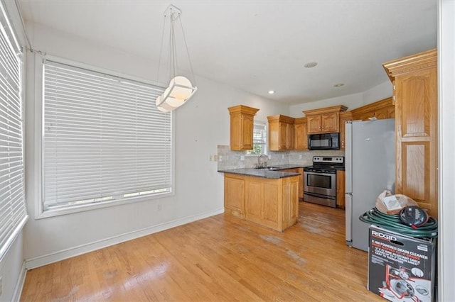 7633 W 148th Ter, Overland Park, KS 66223 - kitchen with stainless steel electric range, black microwave, freestanding refrigerator, a peninsula, and light wood-style floors