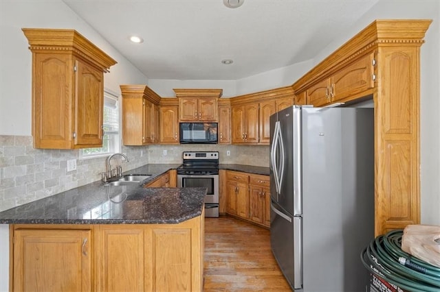 7633 W 148th Ter, Overland Park, KS 66223 - kitchen featuring stainless steel appliances, light wood-style floors, a peninsula, backsplash, and recessed lighting