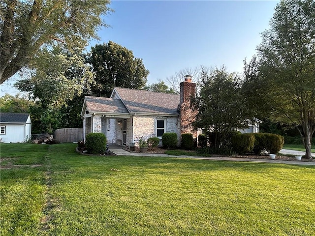 8719 E 57th St, Raytown, MO 64129 - view of front of house with a chimney, brick siding, and a storage shed