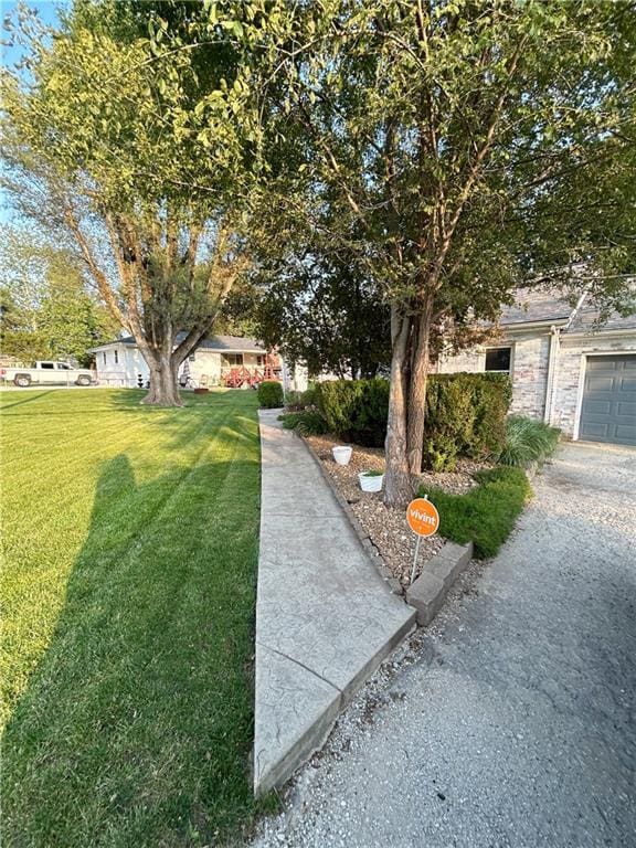 8719 E 57th St, Raytown, MO 64129 - view of green lawn featuring a garage