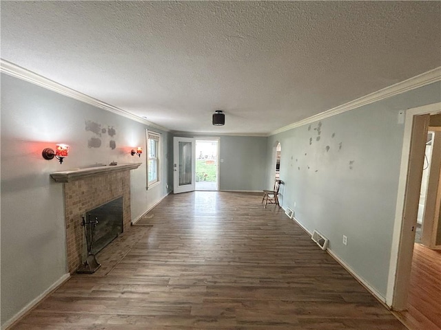 8719 E 57th St, Raytown, MO 64129 - unfurnished living room with a brick fireplace, ornamental molding, wood finished floors, and a textured ceiling