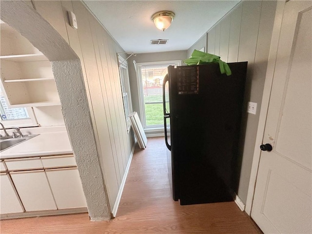 8719 E 57th St, Raytown, MO 64129 - corridor featuring light wood-style flooring and wooden walls