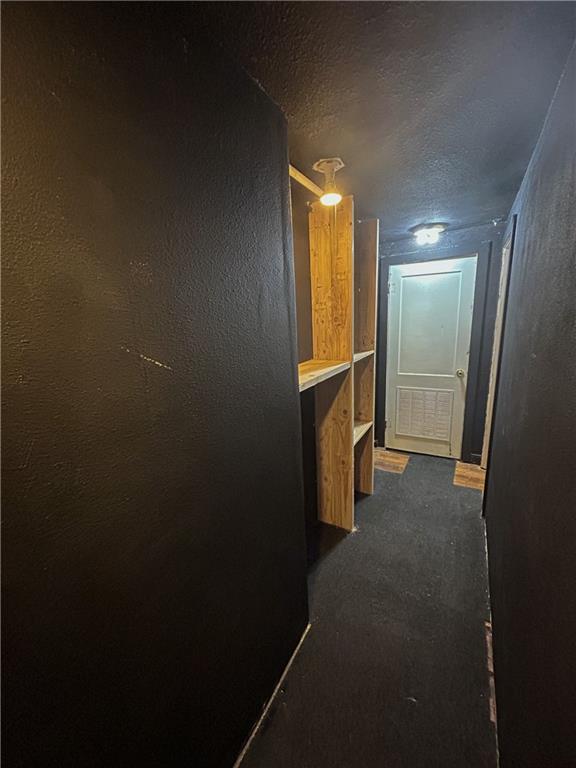 8719 E 57th St, Raytown, MO 64129 - hallway with a textured ceiling and dark colored carpet