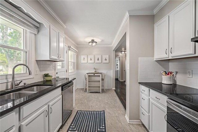 7135 Conser St, Overland Park, KS 66204 - kitchen with stainless steel appliances, ornamental molding, white cabinets, dark stone counters, and tasteful backsplash
