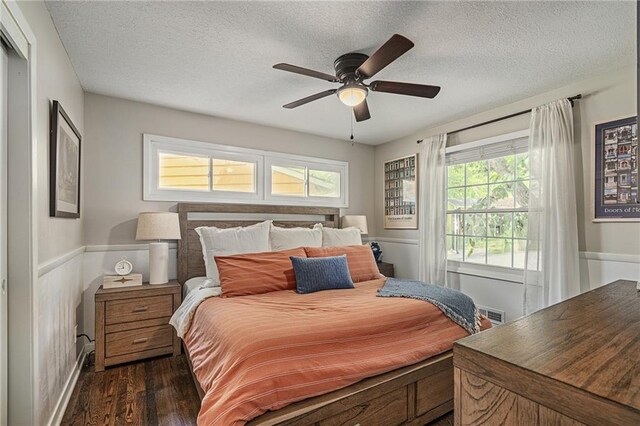 7135 Conser St, Overland Park, KS 66204 - bedroom featuring dark wood finished floors, a textured ceiling, a wainscoted wall, and a ceiling fan
