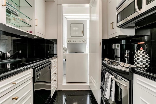 4618 Warwick Blvd Unit 7F, Kansas City, MO 64112 - kitchen with appliances with stainless steel finishes, stacked washer / drying machine, granite tiled floors, tasteful backsplash, and white cabinetry
