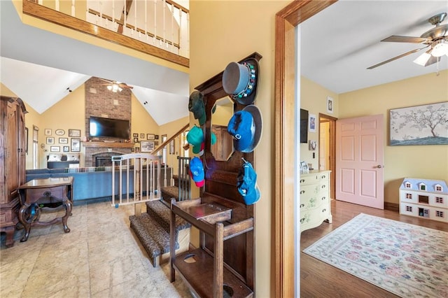 3917 SW Windjammer Ct, Lees Summit, MO 64082 - foyer entrance with a ceiling fan, stairs, wood finished floors, vaulted ceiling, and a fireplace