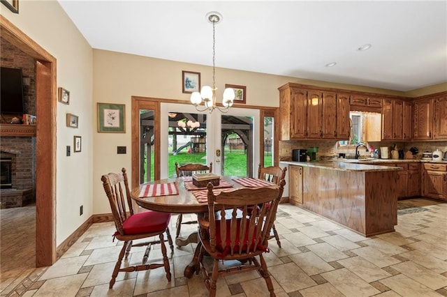 3917 SW Windjammer Ct, Lees Summit, MO 64082 - dining area with stone tile flooring, french doors, a chandelier, a brick fireplace, and baseboards