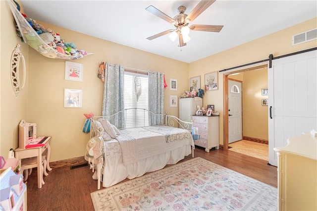 3917 SW Windjammer Ct, Lees Summit, MO 64082 - bedroom with wood finished floors, baseboards, a barn door, and ceiling fan