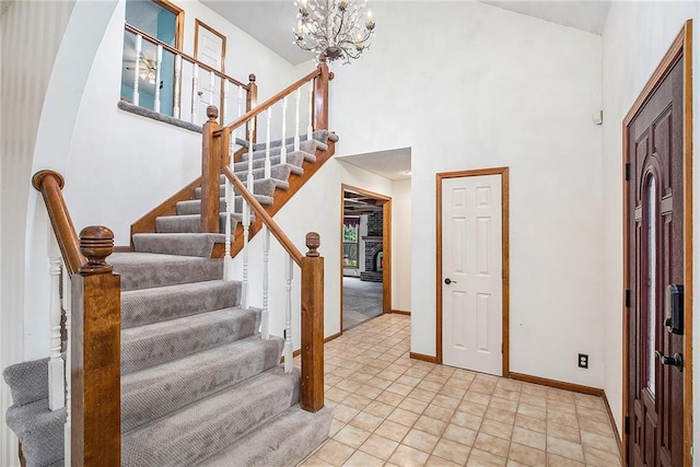 2409 NE 73rd Ter, Gladstone, MO 64118 - entrance foyer with a towering ceiling, stairway, baseboards, and a chandelier