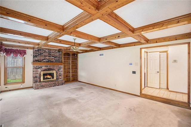 2409 NE 73rd Ter, Gladstone, MO 64118 - unfurnished living room with carpet flooring, baseboards, built in shelves, beam ceiling, and a fireplace