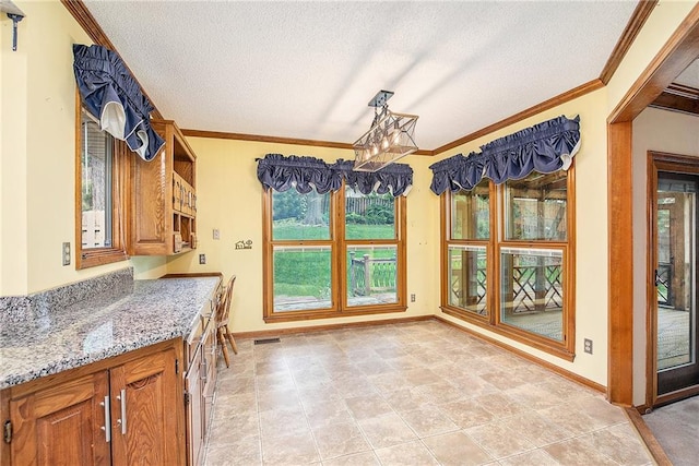 2409 NE 73rd Ter, Gladstone, MO 64118 - dining space with a textured ceiling, crown molding, and baseboards