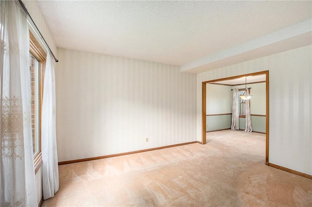 2409 NE 73rd Ter, Gladstone, MO 64118 - empty room featuring carpet, baseboards, wallpapered walls, and a textured ceiling