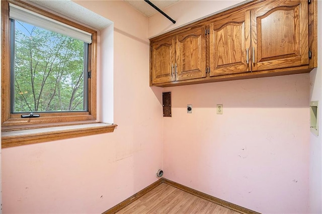 2409 NE 73rd Ter, Gladstone, MO 64118 - washroom with hookup for an electric dryer, light wood-style floors, baseboards, and cabinet space