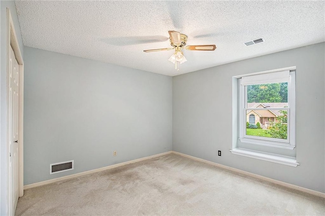 2409 NE 73rd Ter, Gladstone, MO 64118 - empty room featuring light colored carpet, a ceiling fan, baseboards, and a textured ceiling