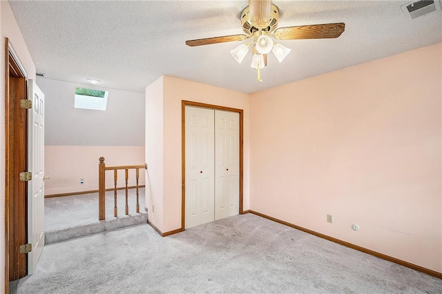2409 NE 73rd Ter, Gladstone, MO 64118 - unfurnished bedroom featuring carpet flooring, baseboards, a closet, a ceiling fan, and a textured ceiling
