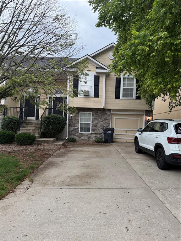 1235 Ashley Ln, Grain Valley, MO 64029 - view of front of home featuring stone siding, concrete driveway, and a garage