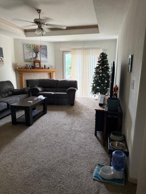 1235 Ashley Ln, Grain Valley, MO 64029 - carpeted living room with a ceiling fan, a tile fireplace, and a tray ceiling