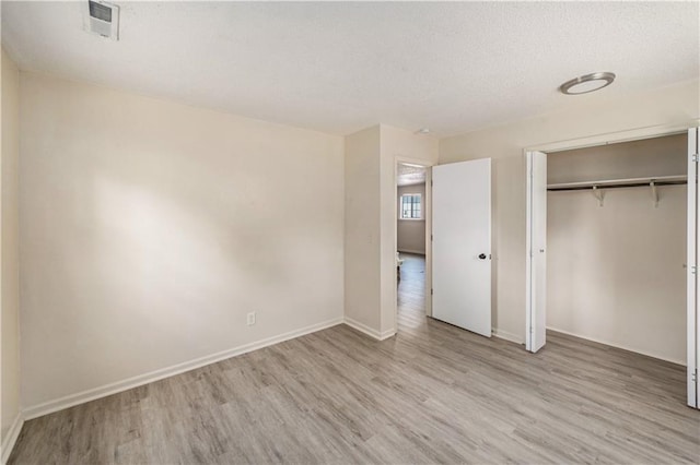 2701 NW 5th St, Blue Springs, MO 64014 - unfurnished bedroom featuring wood finished floors, a textured ceiling, and a closet