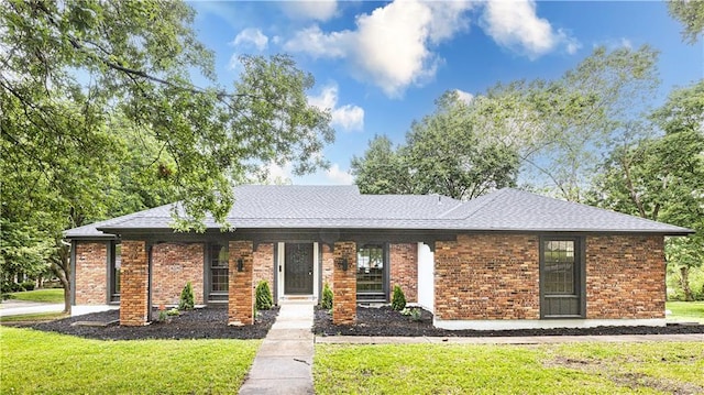 126 E Bridlespur Dr, Kansas City, MO 64114 - view of front of home with a front yard, a shingled roof, and brick siding