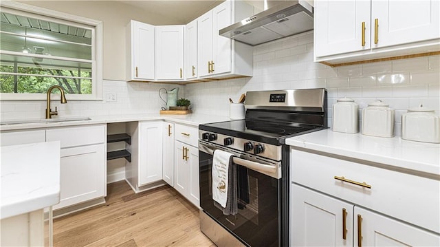 126 E Bridlespur Dr, Kansas City, MO 64114 - kitchen featuring electric range, wall chimney exhaust hood, light wood finished floors, white cabinetry, and a sink