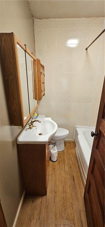123 NW 1501st Rd, Holden, MO 64040 - bathroom featuring wood finished floors, vanity, toilet, and tub / shower combination