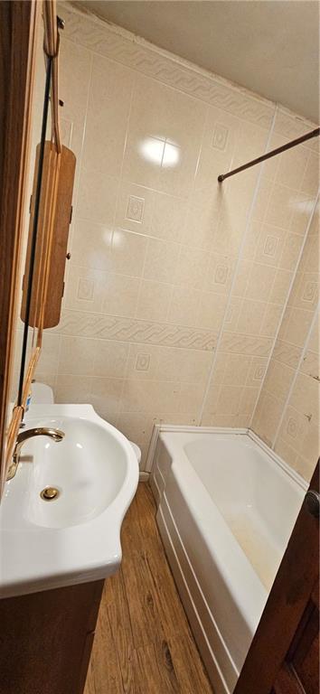 123 NW 1501st Rd, Holden, MO 64040 - full bathroom with wood finished floors, vanity, and washtub / shower combination