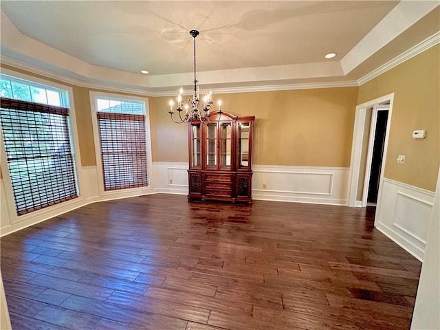 925 S Walnut St, Maryville, MO 64468 - unfurnished dining area with a tray ceiling, a chandelier, dark wood-type flooring, wainscoting, and a decorative wall