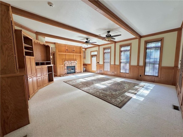 925 S Walnut St, Maryville, MO 64468 - unfurnished living room with carpet flooring, a fireplace, wainscoting, healthy amount of natural light, and beam ceiling