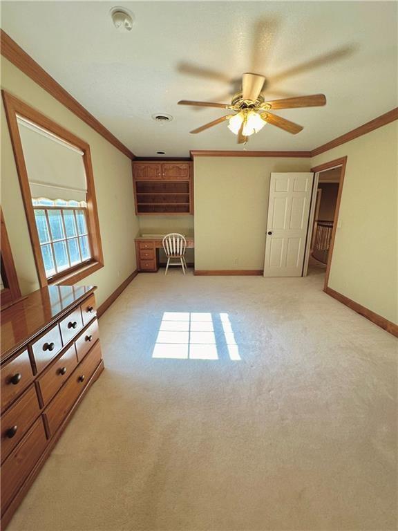 925 S Walnut St, Maryville, MO 64468 - unfurnished living room with baseboards, light carpet, ornamental molding, and ceiling fan