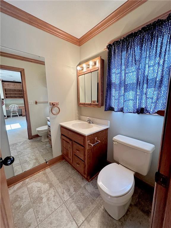 925 S Walnut St, Maryville, MO 64468 - bathroom with toilet, vanity, crown molding, and baseboards