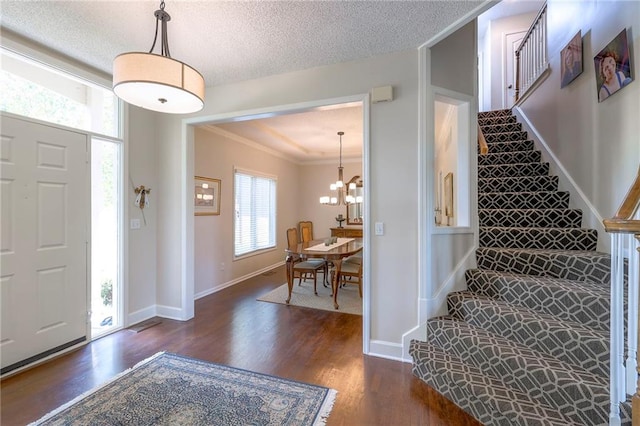8355 Hallet St, Lenexa, KS 66215 - entrance foyer with dark wood-type flooring, stairs, ornamental molding, a chandelier, and a textured ceiling