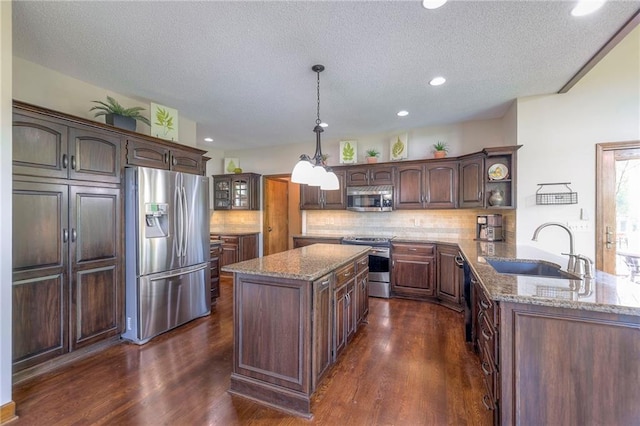 8355 Hallet St, Lenexa, KS 66215 - kitchen featuring appliances with stainless steel finishes, backsplash, dark wood finished floors, light stone counters, and a textured ceiling