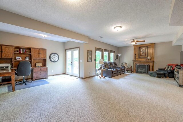 8355 Hallet St, Lenexa, KS 66215 - living room with light colored carpet, a ceiling fan, an office area, a textured ceiling, and a fireplace