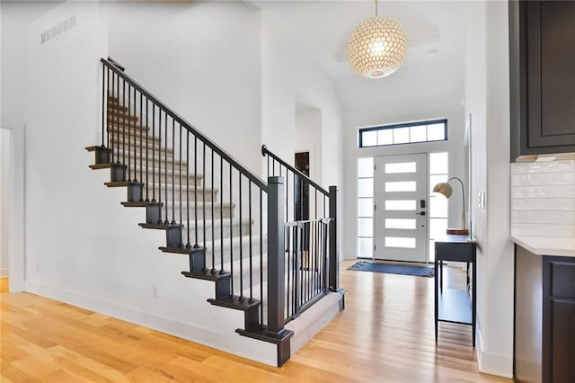 1245 NE Goshen Dr, Lees Summit, MO 64064 - foyer featuring a high ceiling, light wood-type flooring, and stairs
