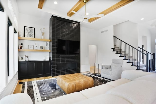 1245 NE Goshen Dr, Lees Summit, MO 64064 - living area featuring light wood finished floors, beam ceiling, recessed lighting, a fireplace, and stairway